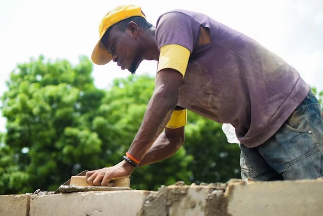 Bricklayer laying bricks to build a wall