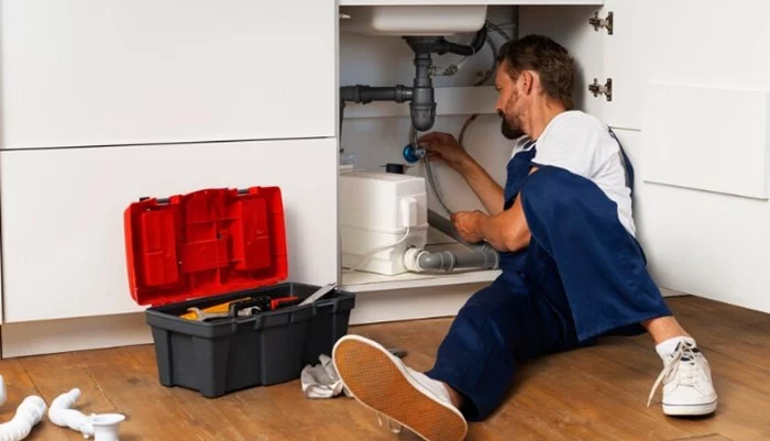 Qualified plumber repairing kitchen sink pipes in a residential home in South Africa
